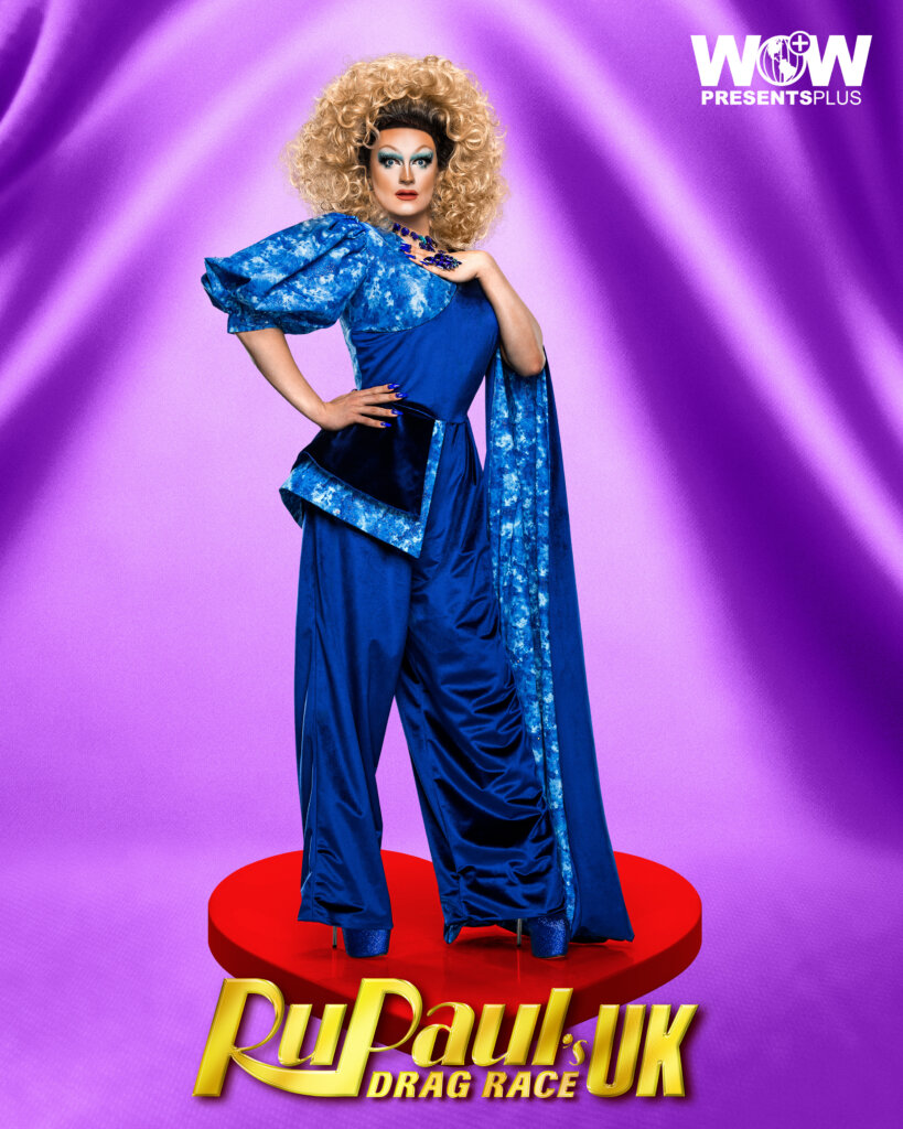 Kate Butch posing for RuPaul's Drag Race UK series 5 promo for Meet The Queens in a blue outfit.