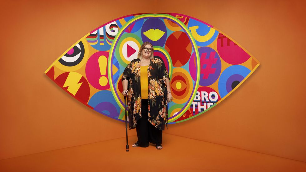 Big Brother 2023 housemate Kerry standing in front of the new eye logo with a bright orange background.