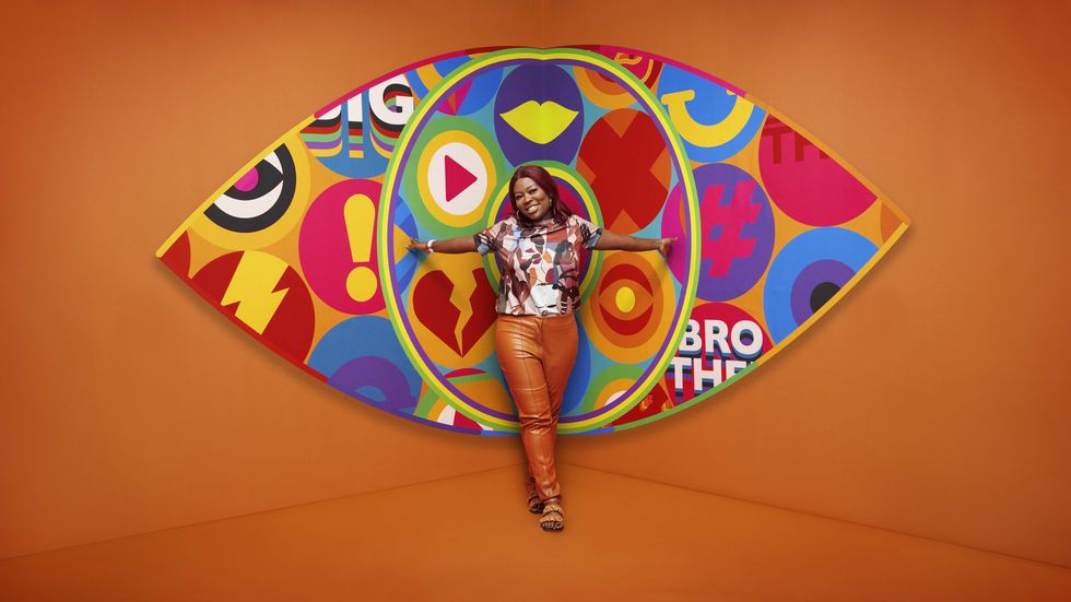 Big Brother 2023 housemate Trish standing in front of the new eye logo with a bright orange background.