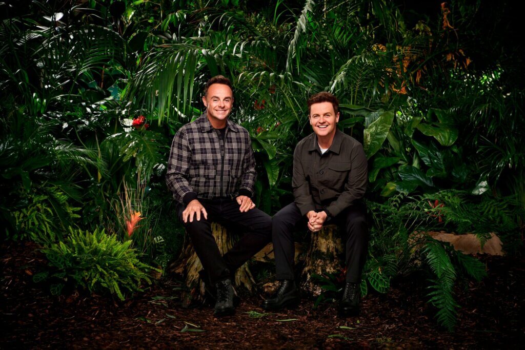 Promotional photo for I'm a Celebrity… Get Me Out of Here! 2023, which sees Ant & Dec sitting in a jungle setting, wearing the camp uniform.