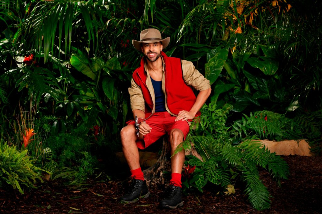 Promotional photo for I'm A Celebrity... Get Me Out Of Here! 2023, which sees Marvin Humes in a jungle setting, wearing the camp uniform.