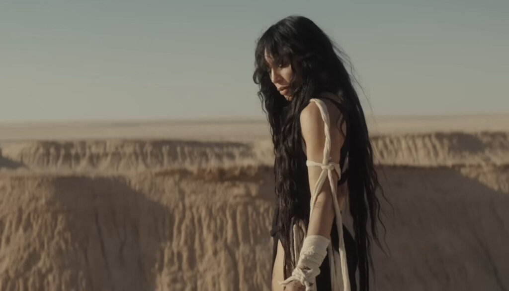 Still from the "Is It Love" music video which sees Loreen overlooking desert hills.