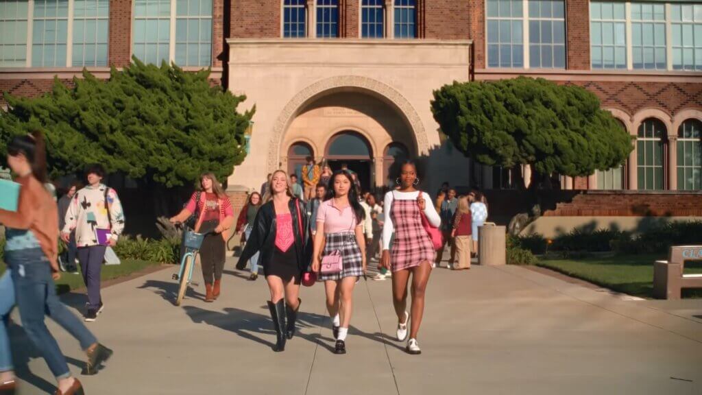 Still from Walmart's Mean Girls reunion advert which sees three new Plastics in front of the school.