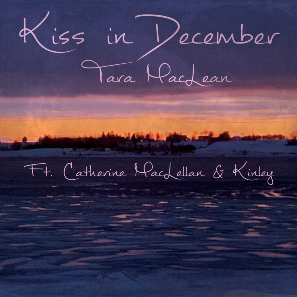 Official single cover artwork for "Kiss in December" which shows a wintry ocean with land in the distance and sunset clouds. The single title is written in the sky alongside Tara MacLean's name, while Catherine MacLellan and KINLEY's names are written in the ocean.