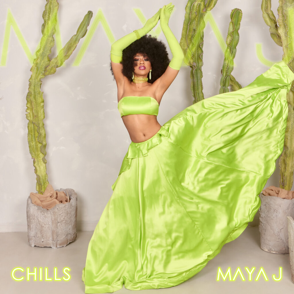 Official single cover artwork for Maya J's latest single "Chills", showing her outside posing against a concrete wall in a lime green top and gown-like skirt.