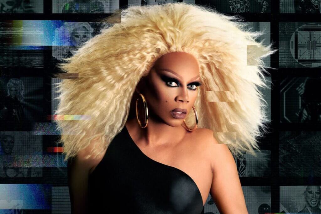 Cropped version of the official promo image of RuPaul for RuPaul's Drag Race Season 16 which sees her in a black dress and a huge blonde wig.