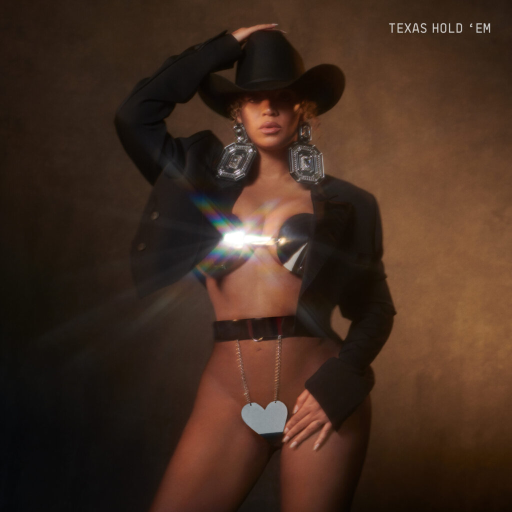 Official single cover artwork for "TEXAS HOLD 'EM" which sees Beyoncé posing with a country hat, a matching black jacket, and a metal two-piece underwear set.