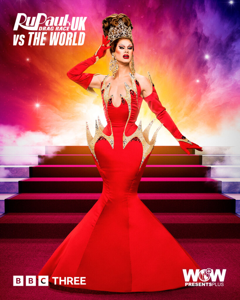 Scarlet Envy from RuPaul's Drag Race UK vs the World series 2, posing in a royal red dress with a red carpet of stairs behind her.