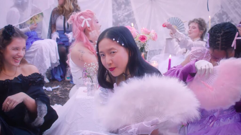 Still from the "Super Fun Party Girl" music video which sees ÊMIA looking stunning in a white dress in the dream-like party world with her girls around her.