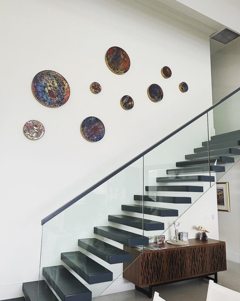 Some of Rick Lowe's circle-themed artwork hanging above a staircase.