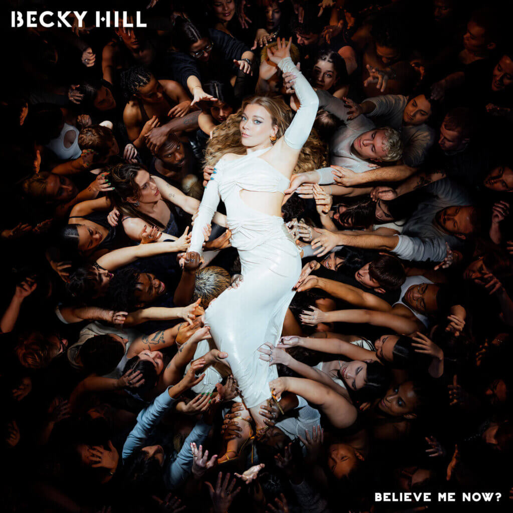 Official album cover artwork for "Believe Me Now?" which sees Becky Hill crowd surfing while wearing a gorgeous white dress. Hands of the people she's crowd surfing on are all reaching for her.