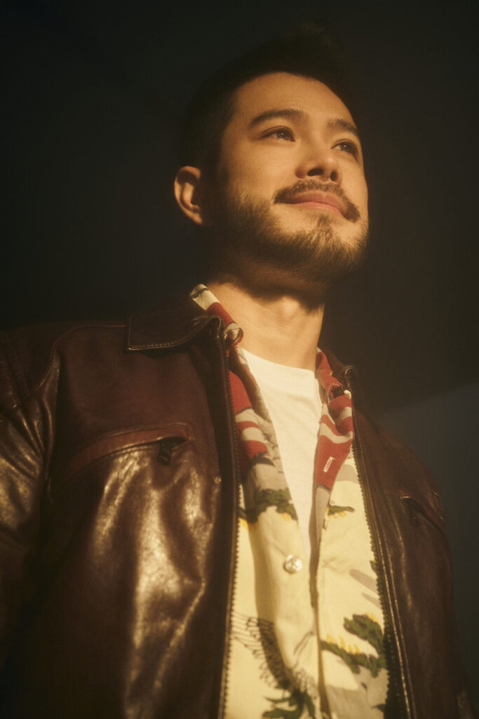 Promotional photo for "Dancing Lights" which sees Wils wearing a brown leather jacket, a cream silk-like shirt and a white vest.