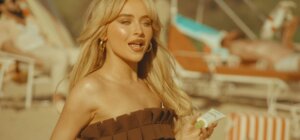 Still from the "Espresso" music video which sees Sabrina Carpenter on a beach.