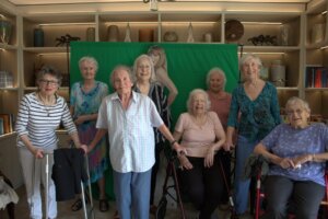 A group photo of the UK's Senior Swifties which sees the care home residents together with the life-size Taylor Swift cardboard cutout behind them.