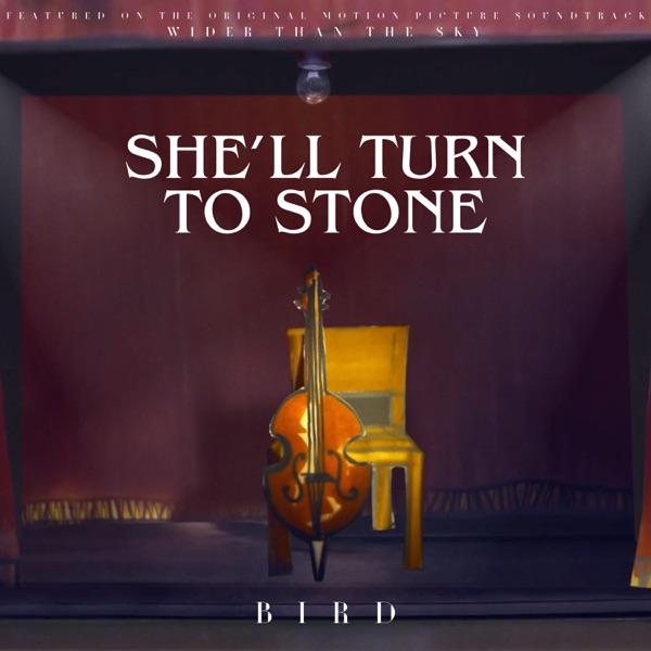 Official single artwork for "She'll Turn To Stone" by Bird which sees a wooden chair against a maroon-painted wall with a cello leaning against the chair.
