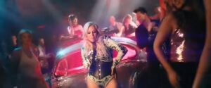 Still from "Call Me" music video which sees Natalie Horler from Cascada posing in front of a mirror-ball-inspired Volkswagen Beetle surrounded by her backing dancers.