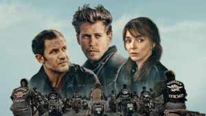 Official image for The Bikeriders film which show Tom Hardy, Austin Butler, and Jodie Comer photoshopped together in the sky while a line of motorcyclists ride on a road below them.