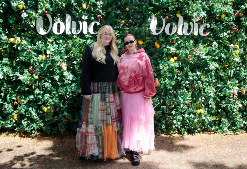 Anne-Marie and Grace Davies posing together in front of the Volvic-branded bush.