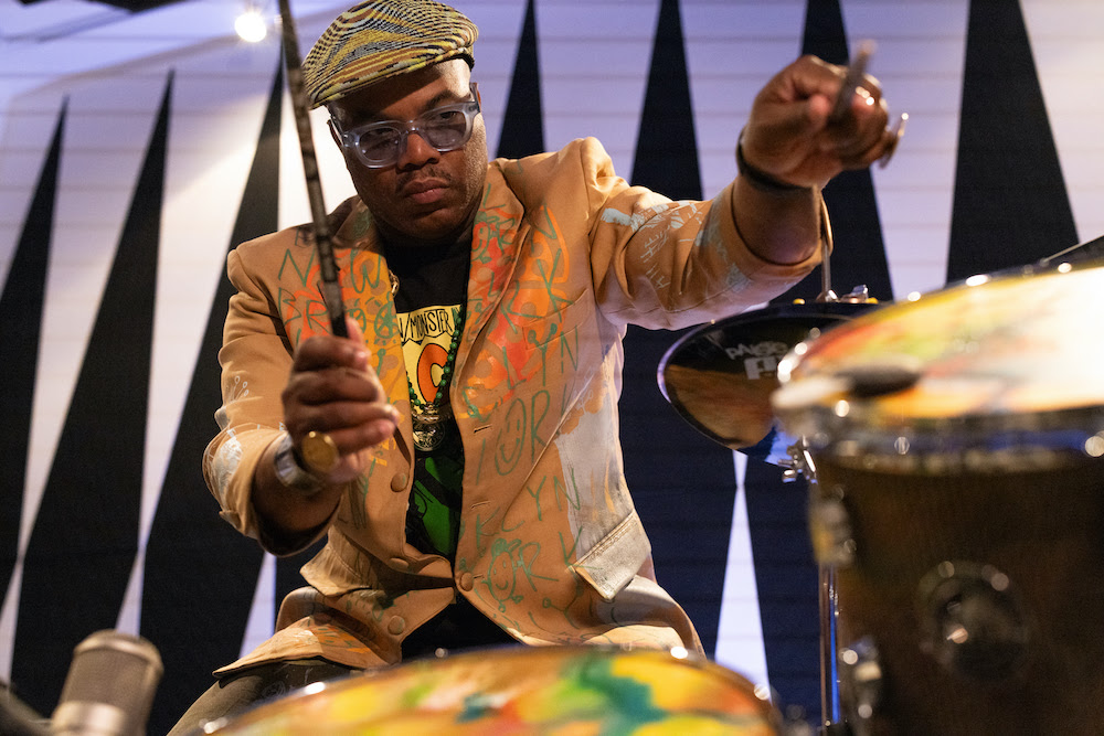 Daru Jones playing the Cardboard Sessions drums with the drumsticks in his hands.