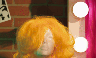 Gif of someone snatching a wig off a head mannequin for the show "Drag: The Musical".