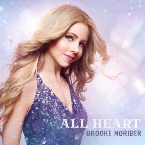 Official EP cover artwork for "All Heart" which sees Brooke Moriber in a blue-purple sequinned dress with her blonde hair being blown behind her while a light blue spotlighted backdrop is behind her.