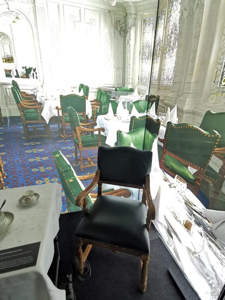 A green leather wooden chair near a dining table.