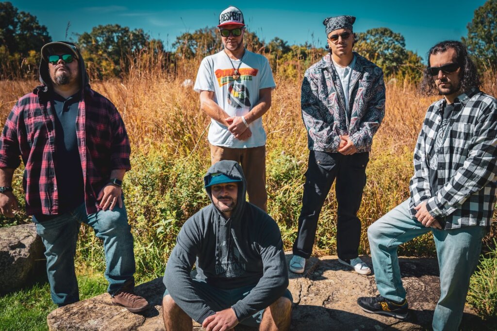 Group photo of IRIEspect standing apart from one another with a field behind them.