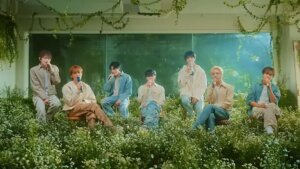 Still from the live performance video that NCT Dream did for "Rains in Heaven" set in a studio full of daisies.