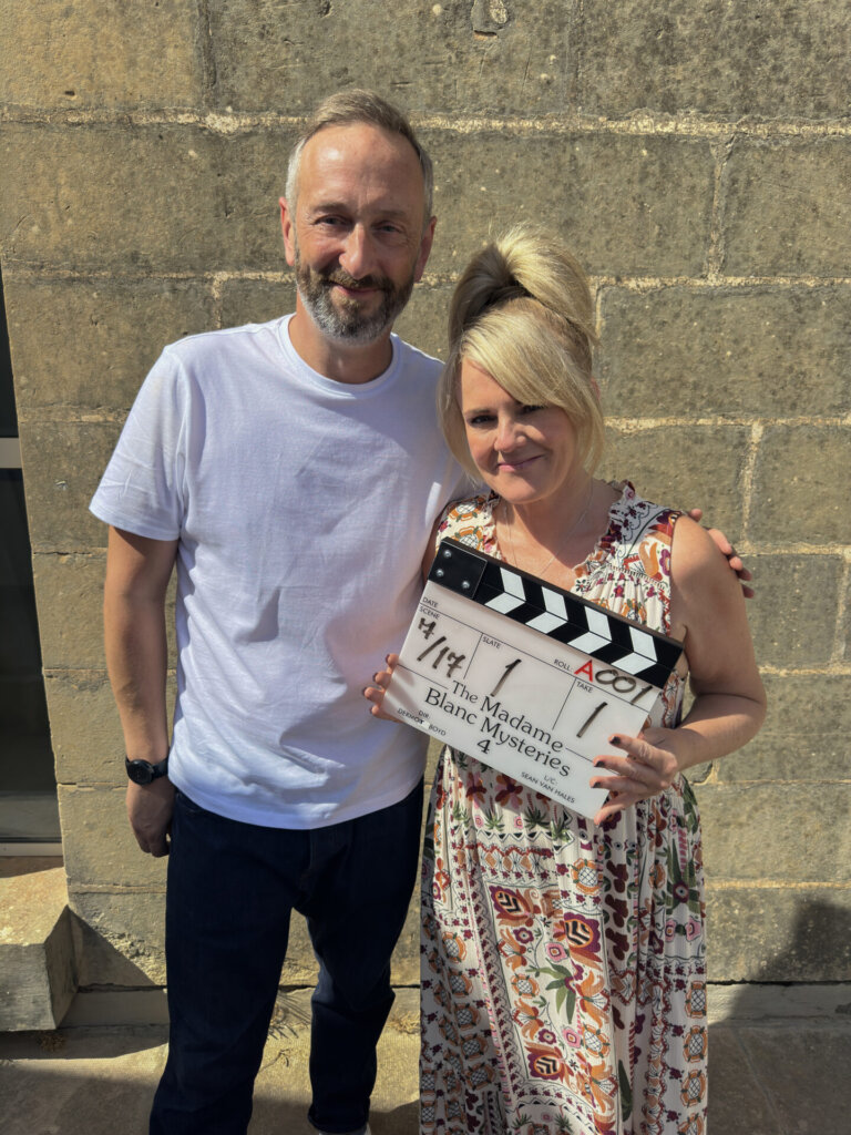 Photo of Sally Lindsay and Steve Edge posing in front of a film clapper board showing that series 4 is being filmed.