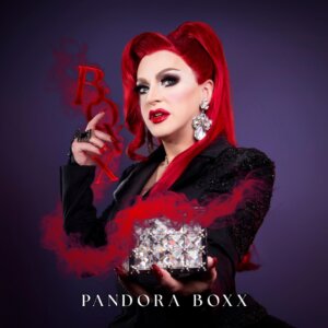 Album cover artwork for "BOXX" which sees Pandora Boxx in a blood-red wig and black clothes with red smoke around her hand and arms like she's casting a spell.