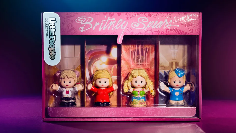 The Fisher-Price Britney Spears Little People figurines in their pink box with the same black background with subtle blue and pink neon lighting.