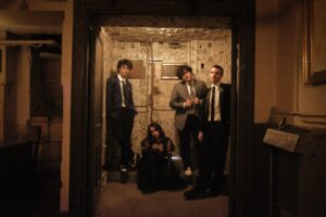 The four-piece band, Phoneboy, posing in a rustic doorway.