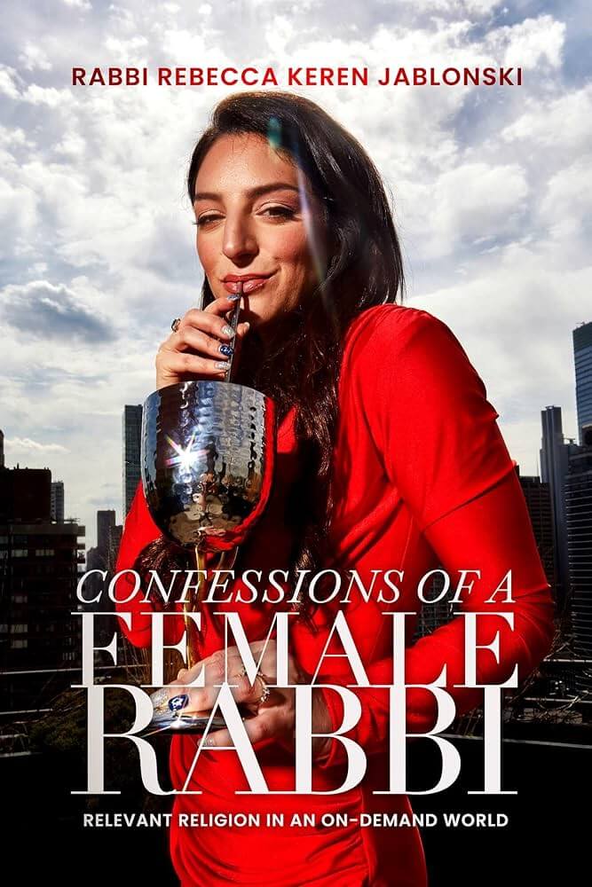 Book cover of "Confessions of a Female Rabbi: Relevant Religion in an On-Demand World" which sees Rabbi Rebecca Keren Jablonski wearing a red dress and drinking from a glass of wine through a straw.